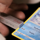 A French Pokemon card having its borders measured.